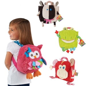 Ein Mädchen mit einem Rucksack mit dem Bild einer rosa Plüsch-Eule mit drei weiteren Plüsch-Rucksäcken mit dem Bild einer Kuh, eines Frosches und eines roten Affen