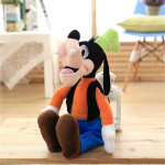 Plüschtier des Disney-Charakters Goofy, der auf einem Parkettboden sitzt und eine blaue Hose und ein orangefarbenes Oberteil trägt