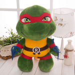 Plüsch-Ninja-Schildkröte mit rotem Stirnband und Zubehör, auf einem Tisch neben einer weißen Lampe und einer grünen Pflanze präsentiert
